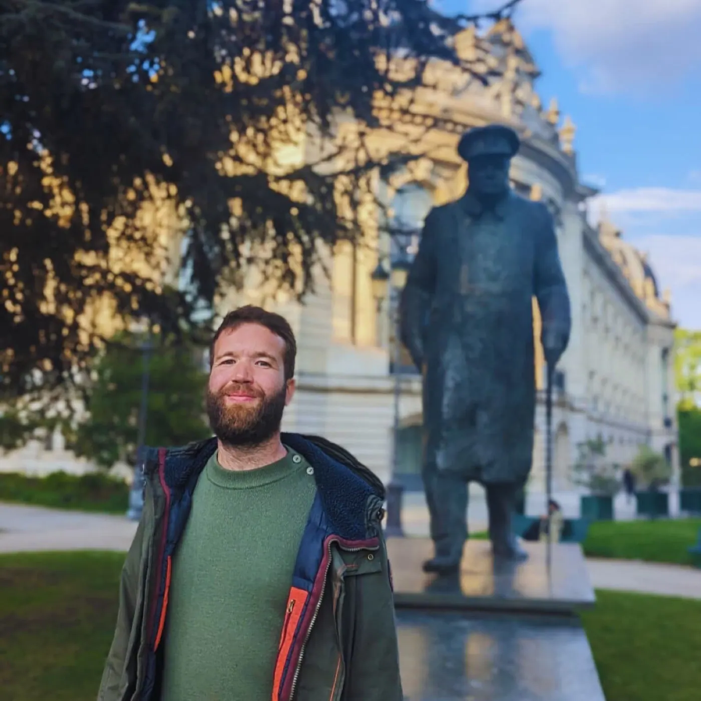 Clément Baissat debout devant une statue de Winston Churchill